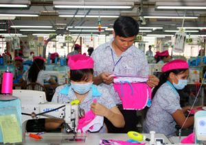 A supervisor oversees his employees’ work in a clothing plant in Vietnam. © BetterWork