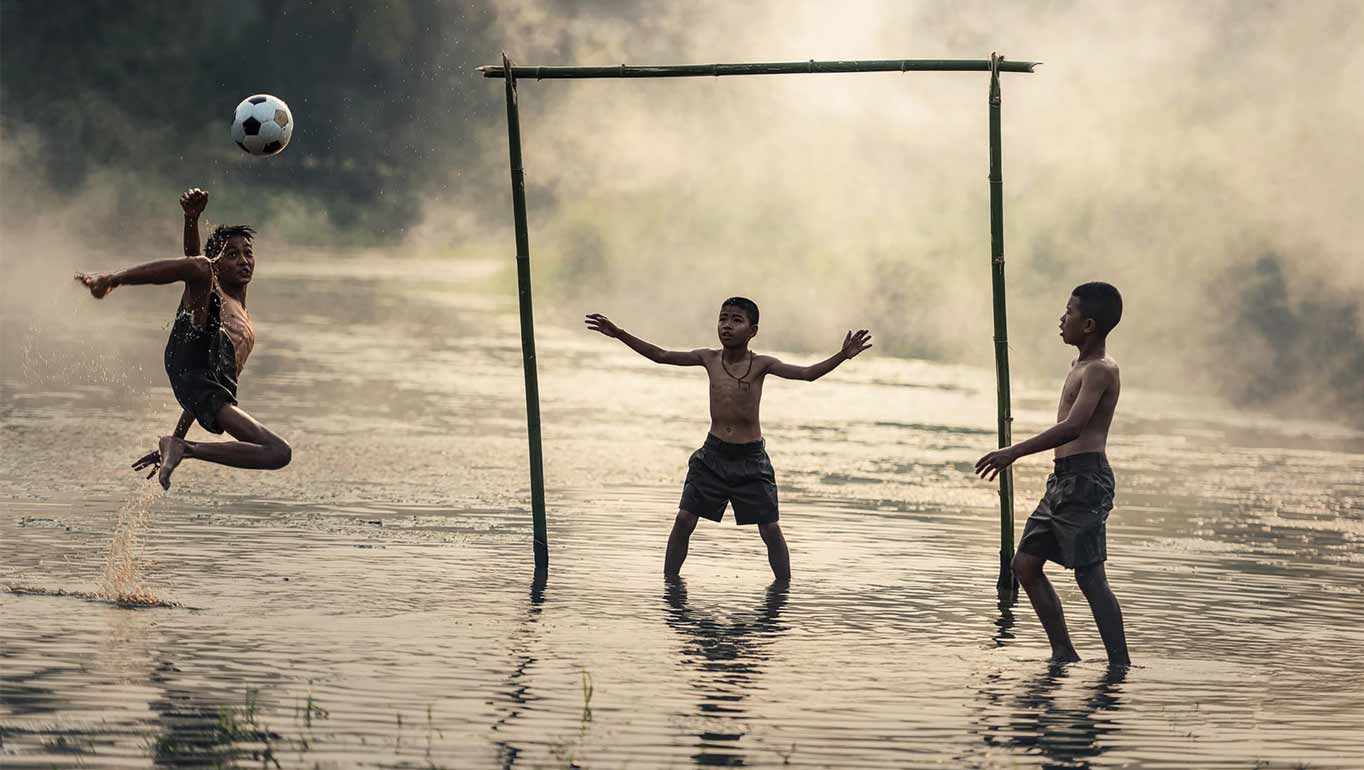 A group of boys playing football during a flood in Brazil